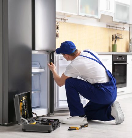 a technician repairing a refrigerator - Expert Appliance Repair Staten Island